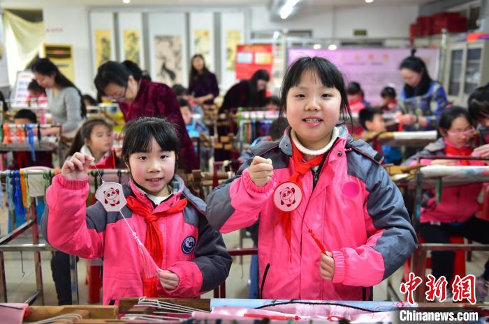 圖為小學(xué)生展示繡制好的2022年北京冬奧會(huì)吉祥物“冰墩墩”形象?！∮髟屏?攝