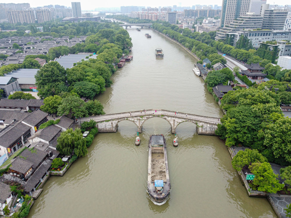 5月27日，一艘貨船駛過(guò)京杭大運(yùn)河南端標(biāo)志建筑杭州拱宸橋。(無(wú)人機(jī)照片)新華社記者江漢 攝