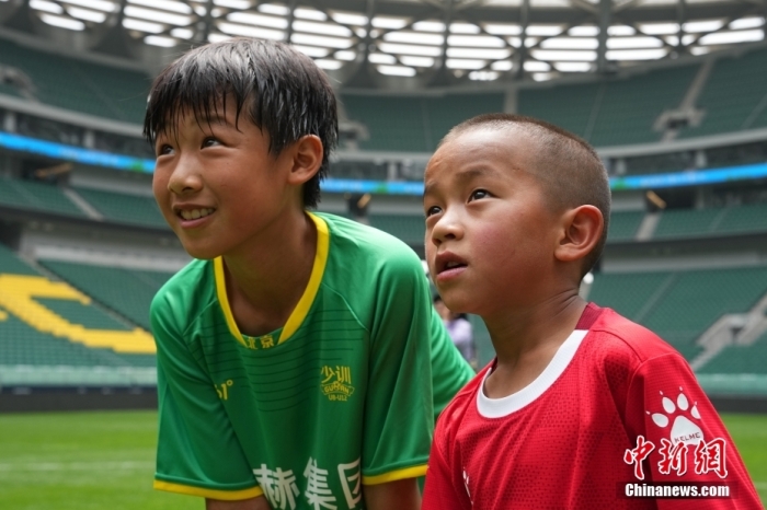 圖為北京國安小球員陳小北和7歲的俄金仁增在一起觀看場內(nèi)播放的紀(jì)錄片。<a target='_blank' href='/' _fcksavedurl='/'><p  align=