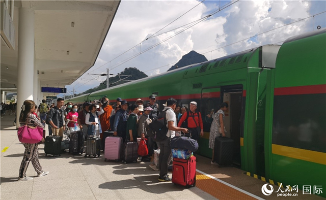 乘坐中老鐵路國際旅客列車的旅客在老撾瑯勃拉邦站排隊上車。人民網(wǎng)記者 杜明明攝