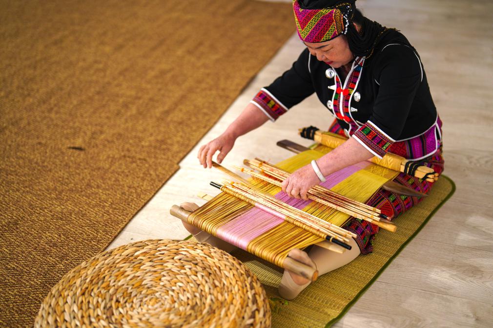 4月17日，黎族傳統(tǒng)紡染織繡技藝國(guó)家級(jí)代表性傳承人劉香蘭在2023年意大利米蘭設(shè)計(jì)周上展示黎錦織造技藝。新華社發(fā)