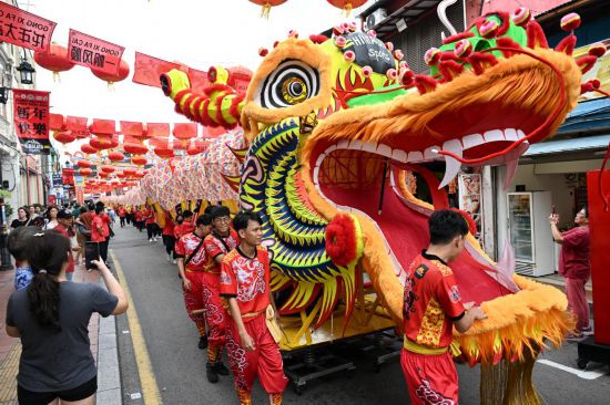 2月1日，由馬來西亞和中國的100多名青少年組成的舞龍隊在馬來西亞馬六甲市雞場街上共舞一條近200米的“長龍”。這是活動現(xiàn)場的“長龍”。新華社記者程一恒攝