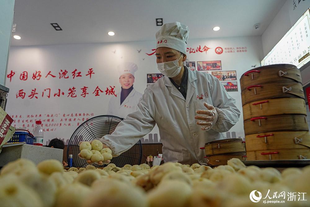 3月31日，在浙江省嵊州市甘霖鎮(zhèn)，嵊州小吃從業(yè)者沈紅平把蒸熟的小籠包晾涼，打包冷藏售賣(mài)。人民網(wǎng) 章勇濤攝