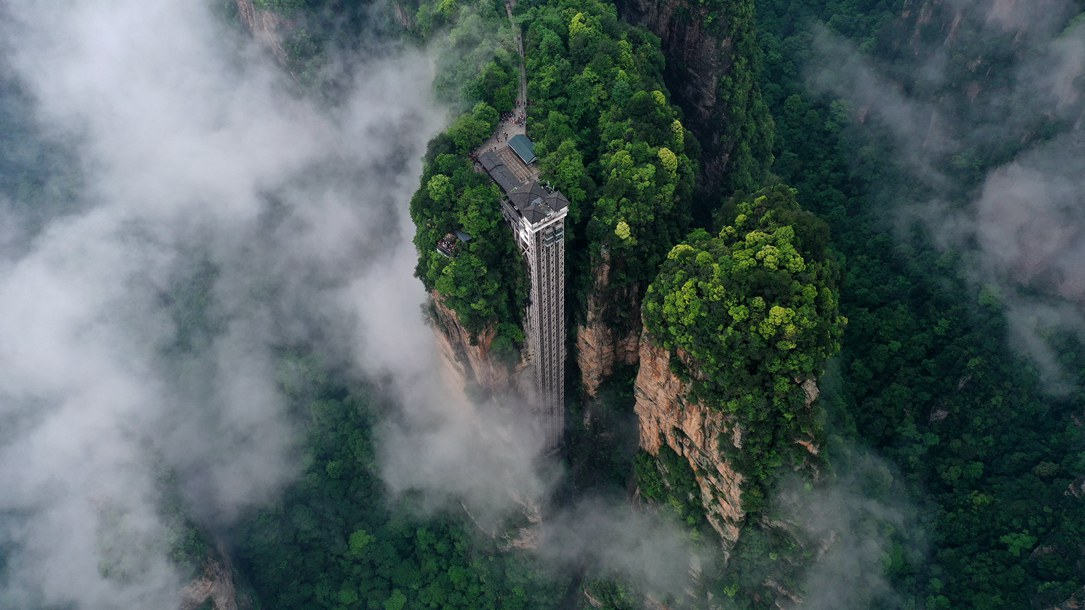 位于張家界武陵源景區(qū)的百龍?zhí)焯蓁偳对谠旗F繚繞的峰林間，雄偉壯觀。吳勇兵攝