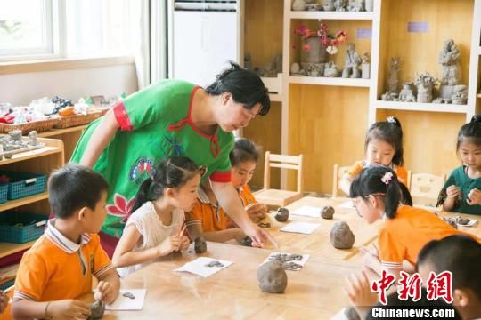 圖為劉雪玲正在給幼教中心的孩子上泥塑課?！＄娦?攝