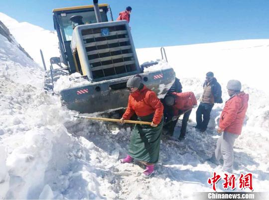 圖為普布卓瑪(左一)與養(yǎng)護工人一起抗擊雪災，搶險保通?！“⒗锏貐^(qū)公路養(yǎng)護段供圖 攝