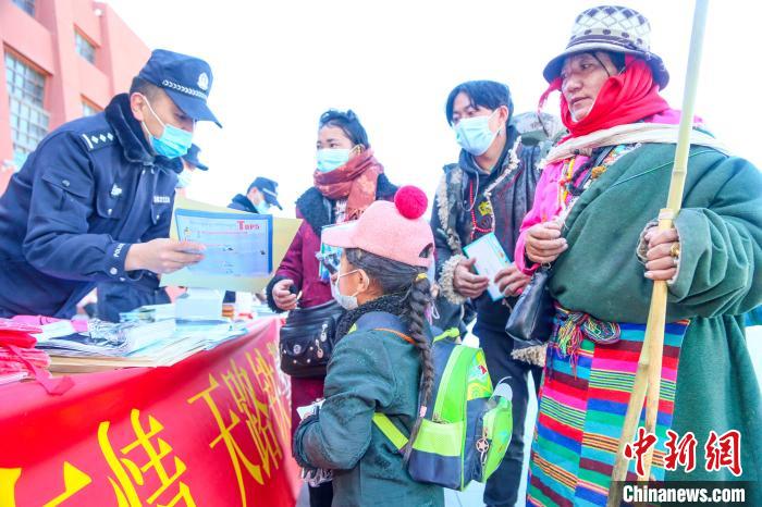 圖為拉薩鐵路公安民警向旅客發(fā)放乘車安全宣傳資料?！↑S飛 攝