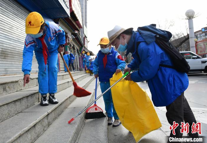 圖為拉薩市小學(xué)生打掃街道?！∝暩聛硭?攝