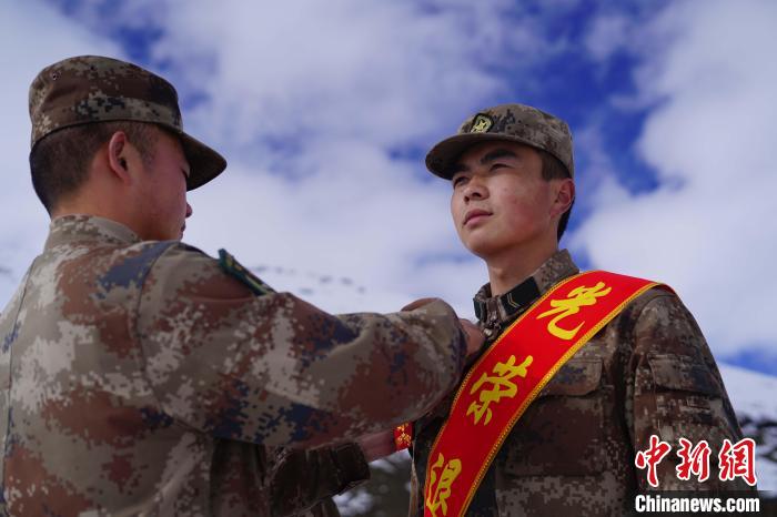 排長(zhǎng)王朝偉(圖左)給退伍老兵佩戴大紅花?！∥鞑厣侥宪姺謪^(qū)某團(tuán)供圖