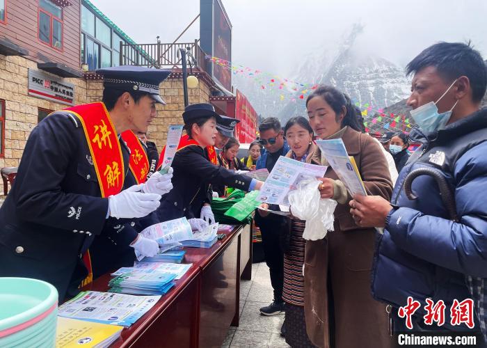 圖為山南玉麥邊境派出所民警為轄區(qū)群眾發(fā)放法律知識(shí)宣傳單?！＄婗?　攝