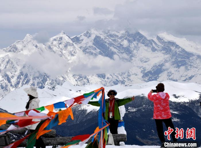 圖為5月14日，西藏林芝色季拉山觀景臺(tái)，游客與南迦巴瓦峰合影?！±盍?攝