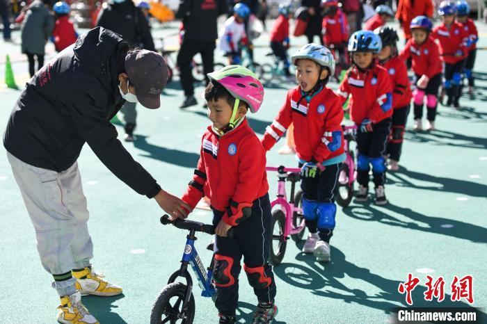 圖為拉薩市實(shí)驗(yàn)幼兒園孩子們在教練的指導(dǎo)下練習(xí)滑步車。　何蓬磊 攝