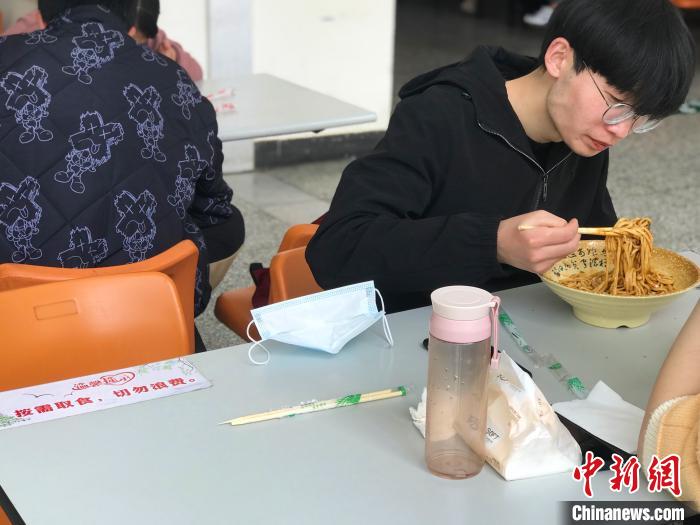 3月17日，西藏大學學生正在學校食堂用餐，餐桌上寫著“按需取餐，切勿浪費”。　冉文娟 攝