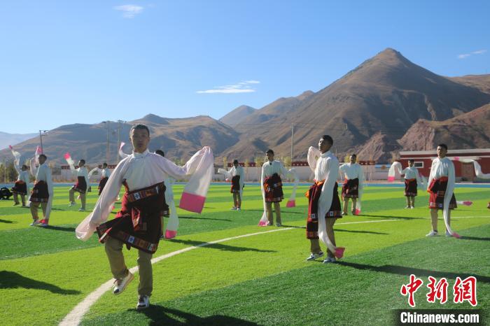 圖為青海師范大學(xué)附屬玉樹實驗學(xué)校學(xué)生在綠茵場跳起囊謙古舞—卓根瑪?！〕逃?攝