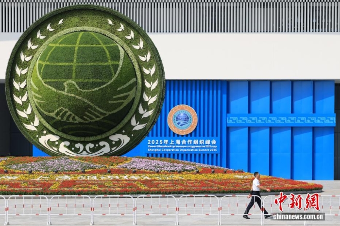 8月31日，天津，一名工作人員從2025年上海合作組織峰會(huì)主會(huì)場外的景觀花壇旁經(jīng)過。當(dāng)日，2025年上海合作組織峰會(huì)在天津舉行。<a target='_blank' href='/'><p  align=