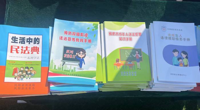 有關部門分發(fā)的普法宣傳冊。人民網 高清揚攝