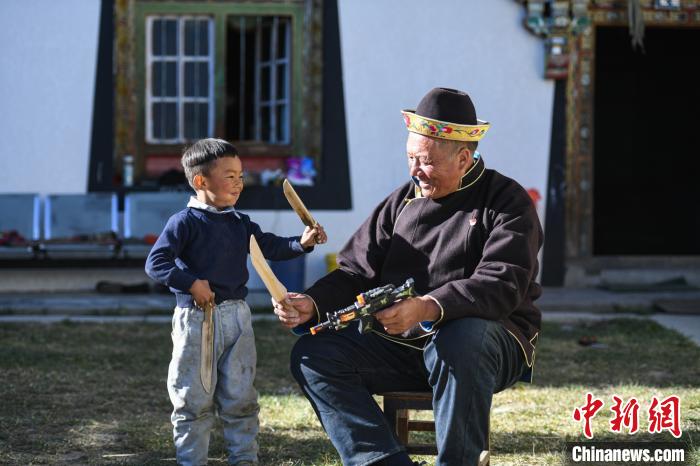 圖為米林縣扎西繞登鄉(xiāng)彩門村64歲的洛桑帶著孫子巴桑在院子的草地上玩耍?！『闻罾?攝