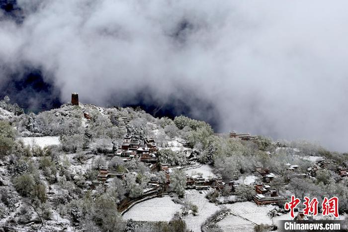 雪后的藏寨和碉樓構(gòu)成美麗的雪景?！〗党鯘衫?攝