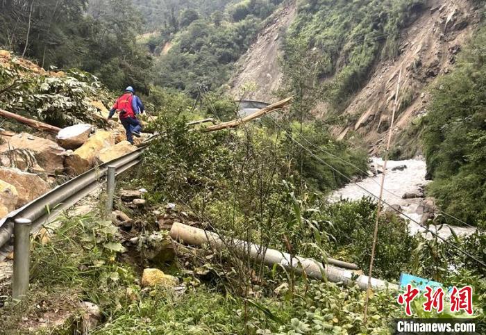 電力搶險人員快速通過危險路段，旁邊是受損的電力線路 四川電力供圖