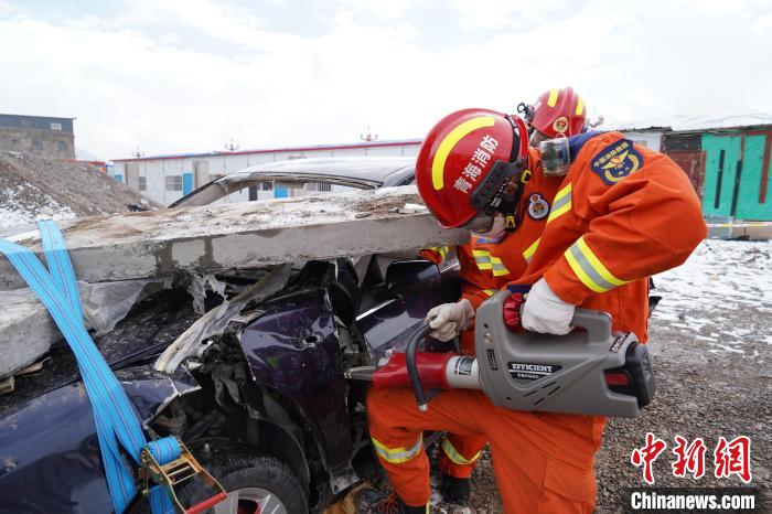 圖為地震實戰(zhàn)拉動現(xiàn)場，參演人員進行車輛破拆?！∮駱湎拦﹫D