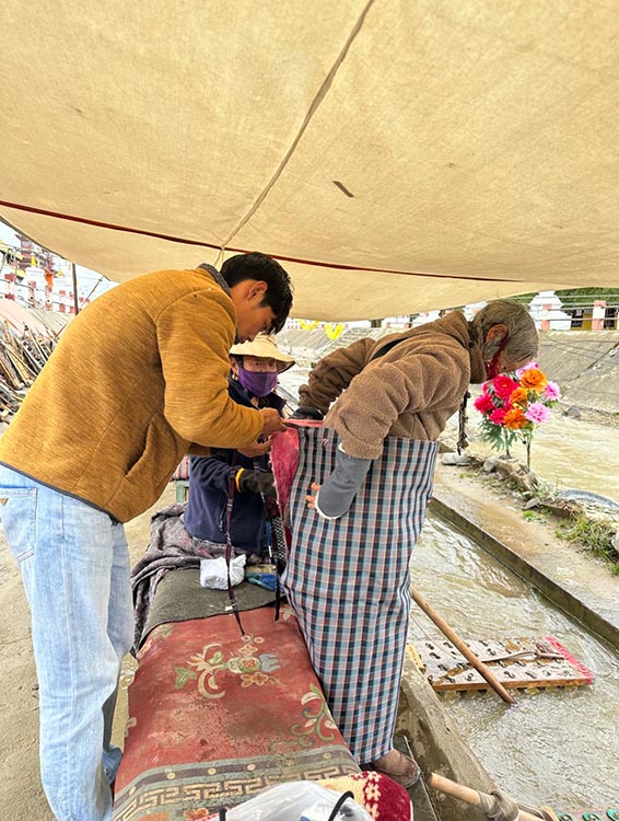 扎西奪爾登為路邊老人送去保暖圍腰。阿壩州文明辦供圖
