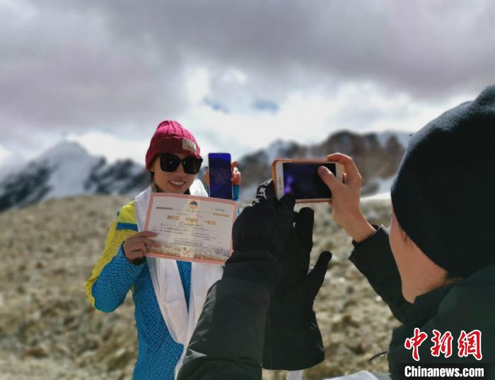 圖為5日，登頂洛堆峰的登山者獲得西藏自治區(qū)登山協(xié)會(huì)頒發(fā)的登頂證明?！垈?攝