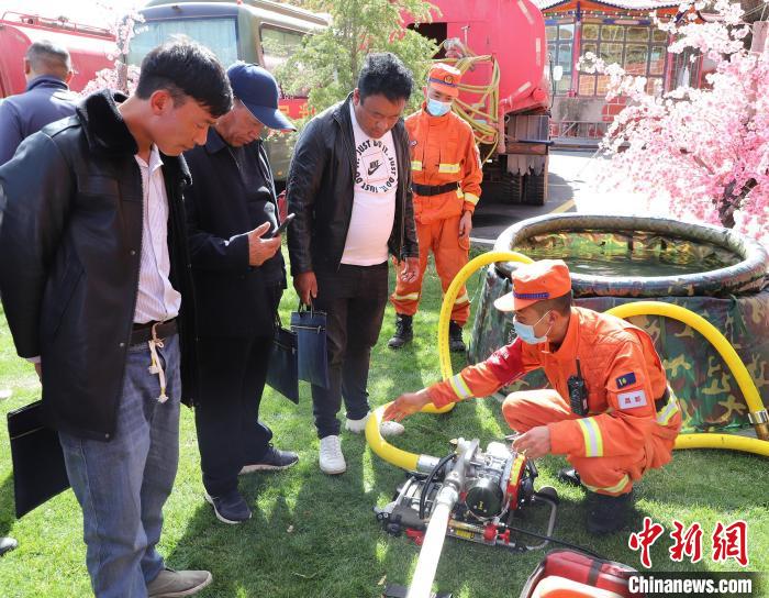 圖為森林消防員為護林員講解滅火裝備的使用方法。　昌都市森林消防支隊 供圖