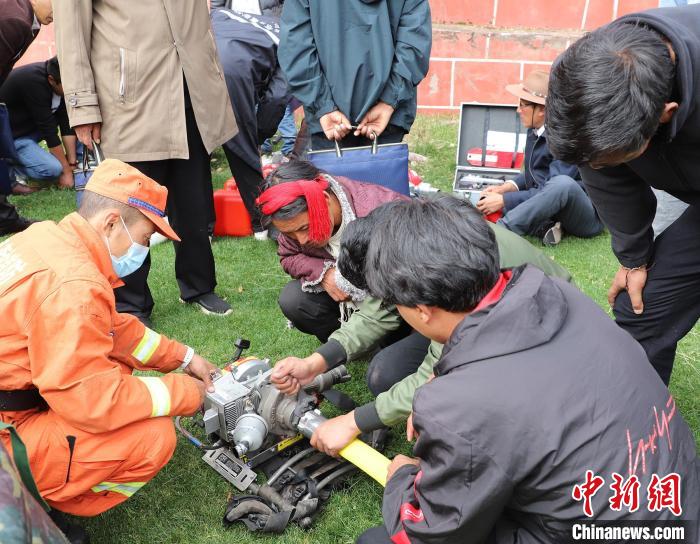 圖為森林消防員為護林員講解滅火裝備的使用方法?！〔际猩窒乐ш?供圖