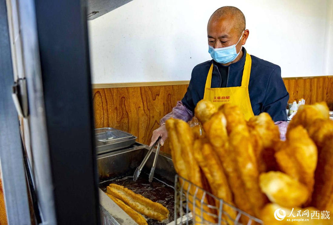 早餐店老板正在炸油條。人民網(wǎng) 次仁羅布攝