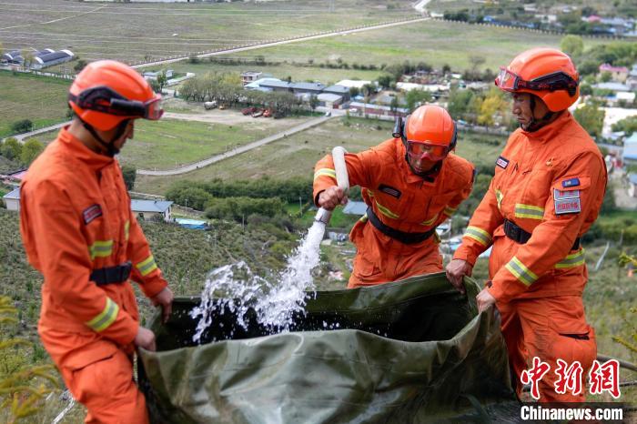 技能大練兵過程中，消防員在陡坡上向蓄水池注水。　李國(guó)燾 攝