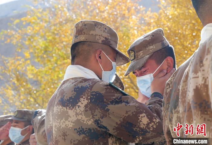 圖為什布奇邊防連退伍老兵與戰(zhàn)友相擁而泣，依依惜別。　徐昌成 攝