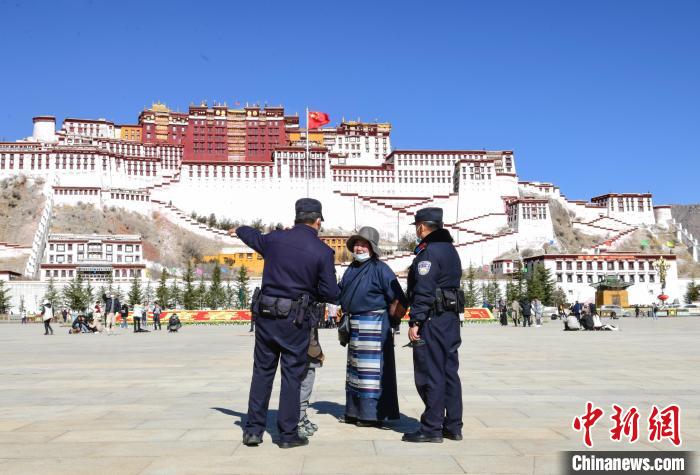 圖為1月23日，布達(dá)拉宮廣場(chǎng)派出所民警正在回答民眾咨詢?！∝暩聛?lái)松 攝