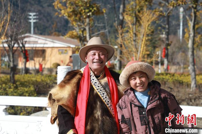 圖為林芝市巴宜區(qū)布久鄉(xiāng)仲果村村民桑杰與孫子一起參加藏歷新年活動?！埩?攝