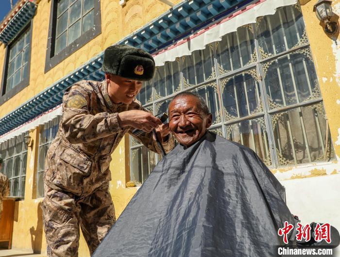 圖為阿里軍分區(qū)某邊防團(tuán)官兵為駐地群眾理發(fā)迎藏歷新年?！〉┰鰝愔?攝