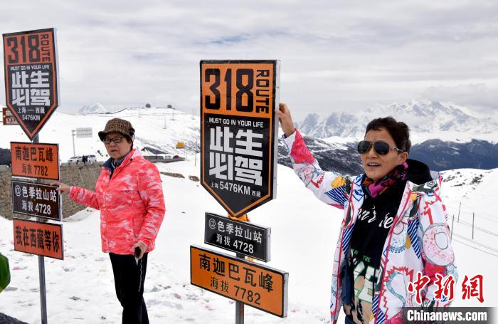 圖為5月14日，西藏林芝色季拉山觀景臺，游客與南迦巴瓦峰合影?！±盍?攝