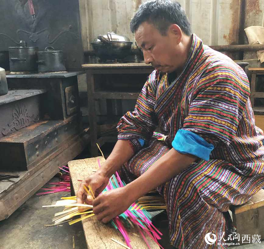 門巴族漢子愛明正在編織藤竹品。